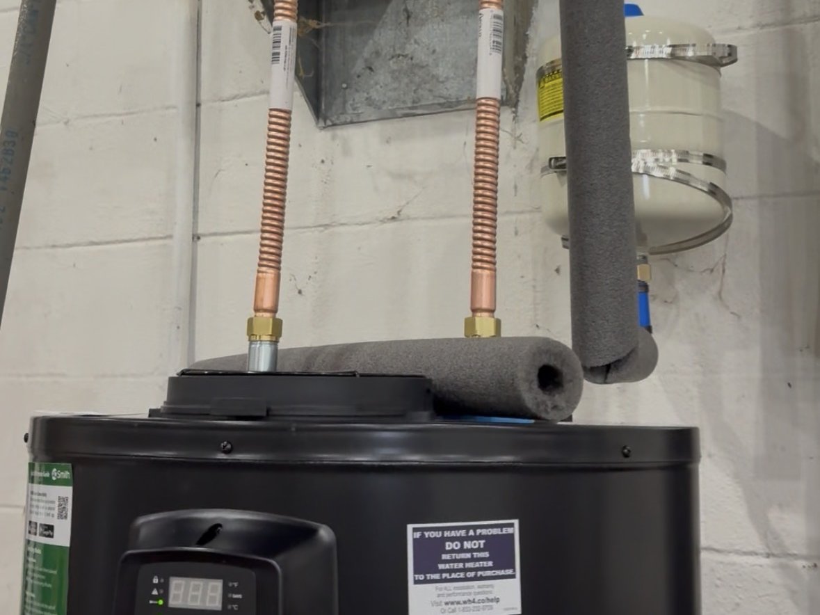Newly installed electric water heater with copper supply lines and connections